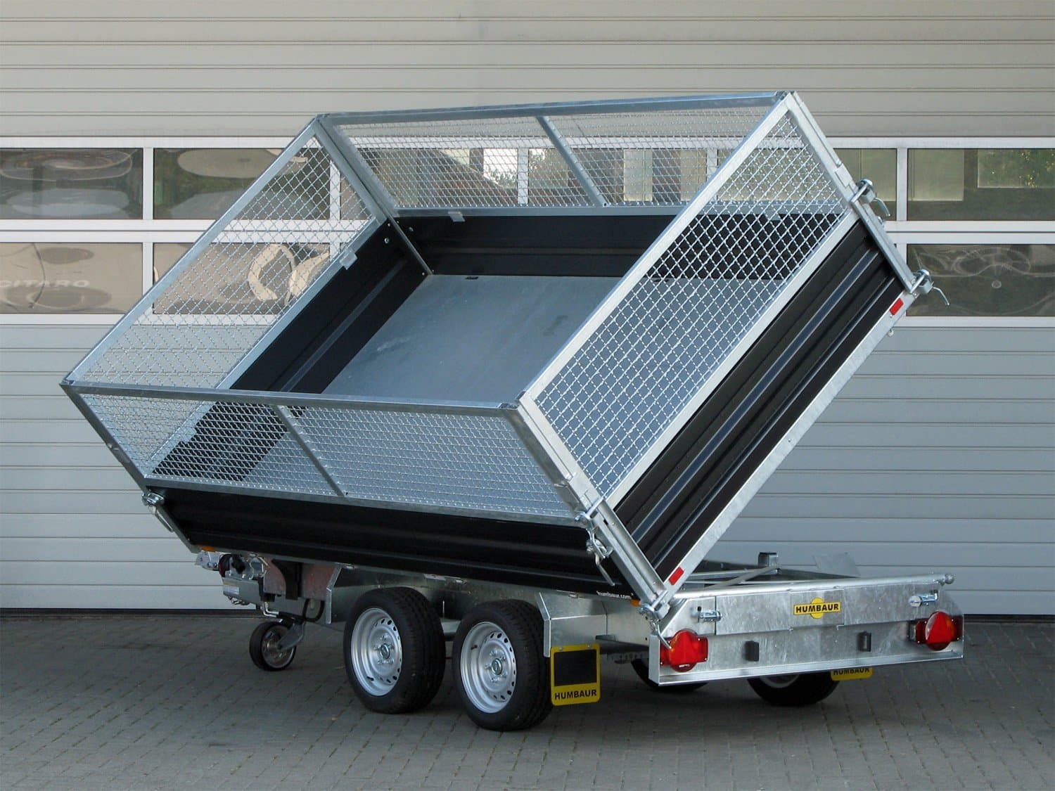Humbaur HTK 3000.31 Dreiseitenkipper aus Stahl mit elektrischer Pumpe und 800 mm hohem Gitteraufsatz